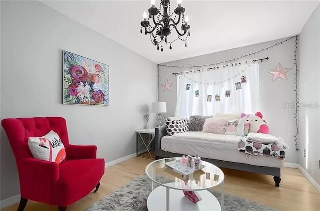 living room featuring baseboards, a chandelier, and wood finished floors