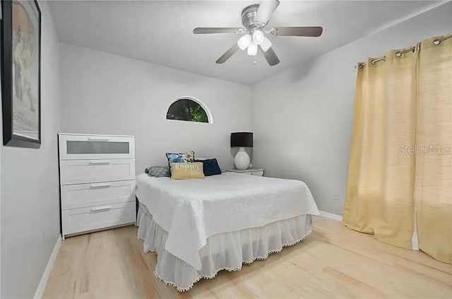 bedroom featuring baseboards, a ceiling fan, and light wood-style floors