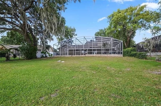 view of yard with a lanai and fence