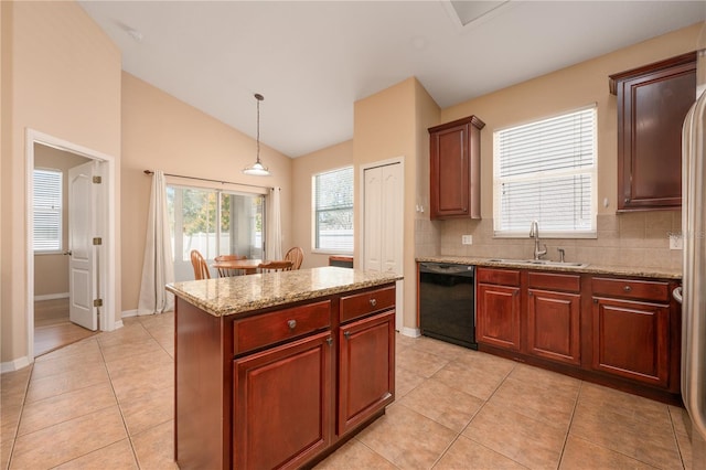 kitchen featuring dishwasher, a kitchen island, light stone counters, decorative light fixtures, and a sink