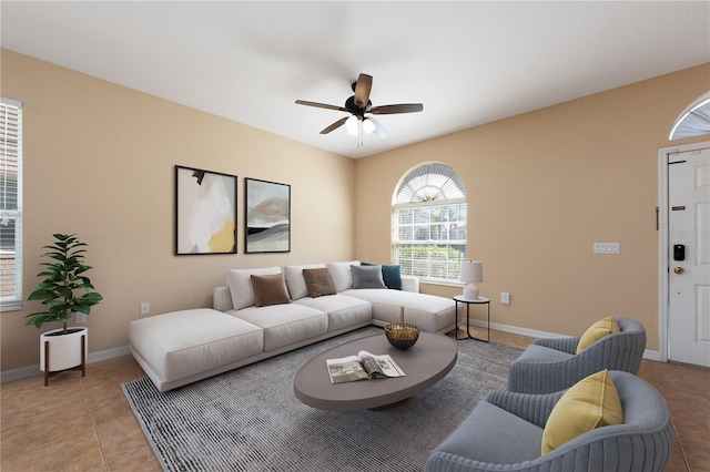 tiled living room featuring a ceiling fan and baseboards