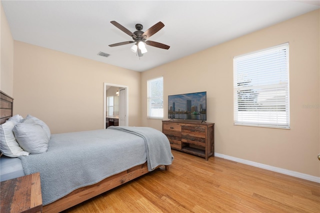 bedroom featuring light wood-type flooring, visible vents, baseboards, and multiple windows