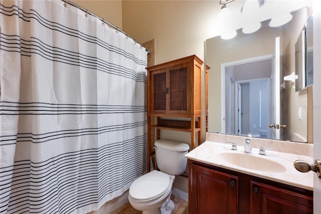 bathroom featuring toilet, vanity, and a shower with curtain