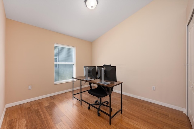 home office with light wood finished floors, baseboards, and vaulted ceiling