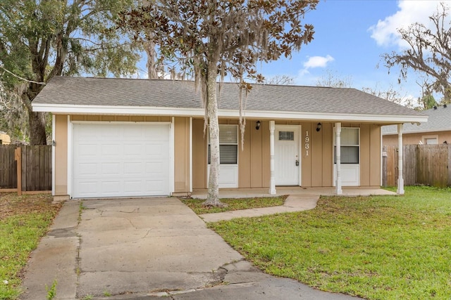 ranch-style home with board and batten siding, a front lawn, fence, and an attached garage