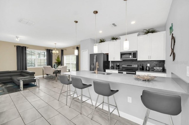 9017 Dogleg Dr, Davenport, FL 33896 - kitchen featuring visible vents, backsplash, a breakfast bar area, stainless steel appliances, and a sink
