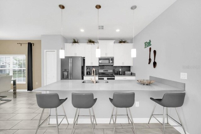 9017 Dogleg Dr, Davenport, FL 33896 - kitchen featuring a sink, decorative backsplash, a kitchen bar, and stainless steel appliances