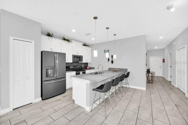 9017 Dogleg Dr, Davenport, FL 33896 - kitchen with a kitchen bar, a peninsula, white cabinets, stainless steel appliances, and a sink