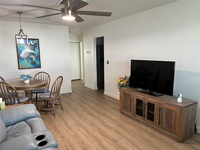 living room featuring ceiling fan and light hardwood / wood-style floors