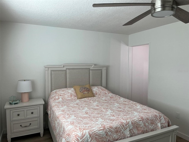 bedroom with dark hardwood / wood-style flooring, ceiling fan, and a textured ceiling