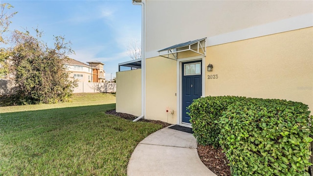 view of exterior entry featuring a yard