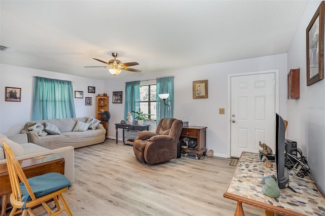 living room with ceiling fan, visible vents, light wood-style flooring, and baseboards