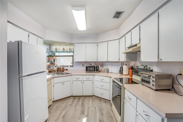 kitchen featuring white appliances, under cabinet range hood, white cabinetry, and light countertops