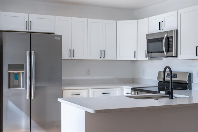 kitchen featuring stainless steel appliances, white cabinets, and kitchen peninsula