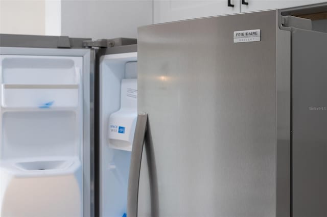 interior details featuring white cabinetry and stainless steel fridge