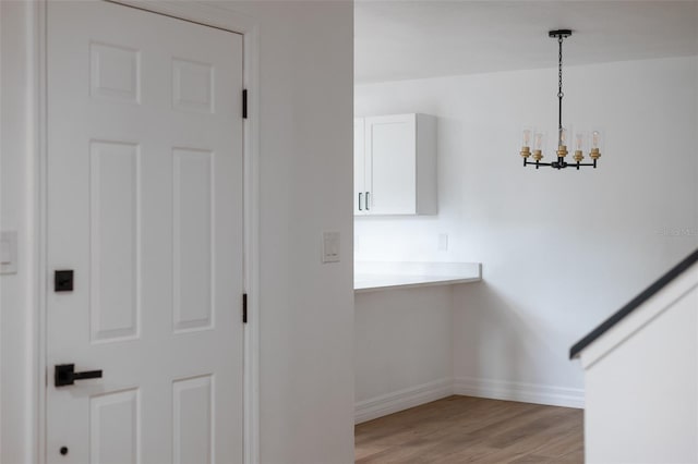 stairway featuring an inviting chandelier and hardwood / wood-style flooring