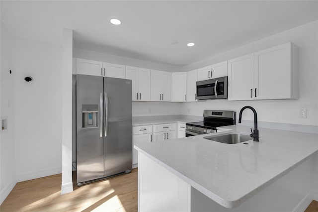 kitchen with white cabinetry, stainless steel appliances, and kitchen peninsula