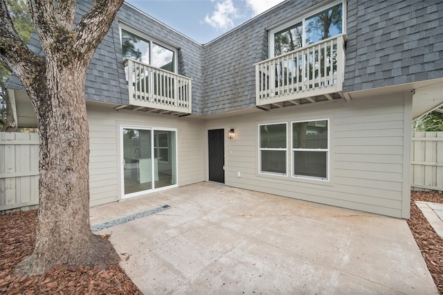 back of property featuring a balcony and a patio area