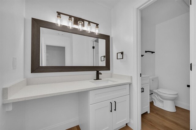 bathroom with vanity, hardwood / wood-style floors, and toilet