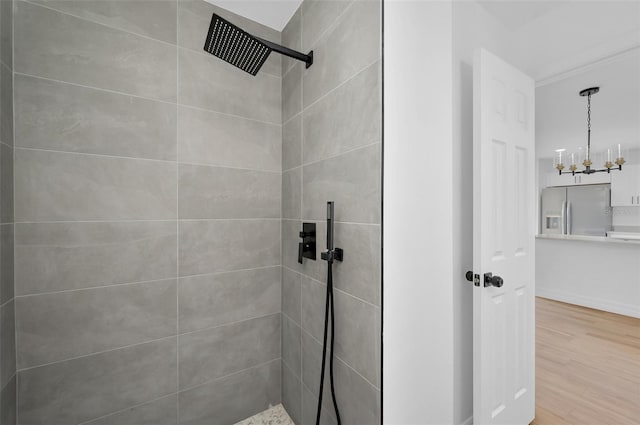 bathroom featuring wood-type flooring, a chandelier, and tiled shower