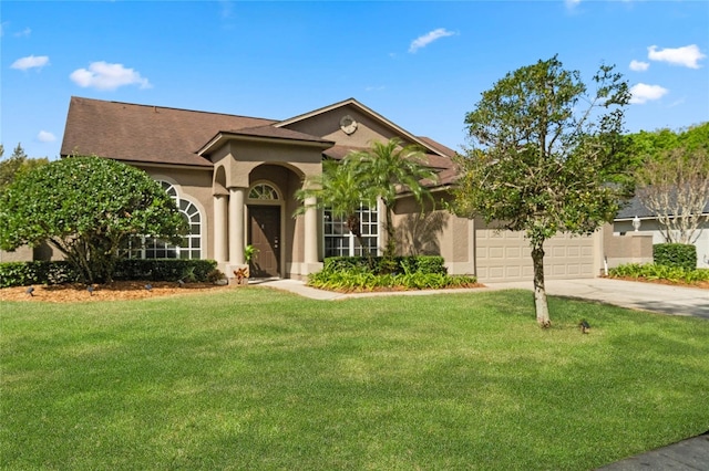 view of front of house featuring an attached garage, a front lawn, concrete driveway, and stucco siding