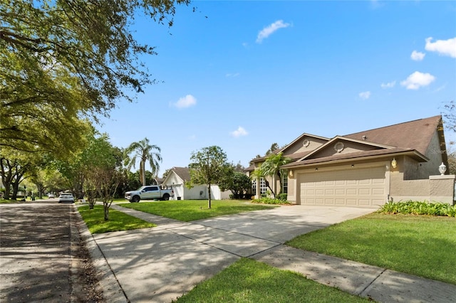 view of front of property featuring a garage, a front yard, concrete driveway, and stucco siding