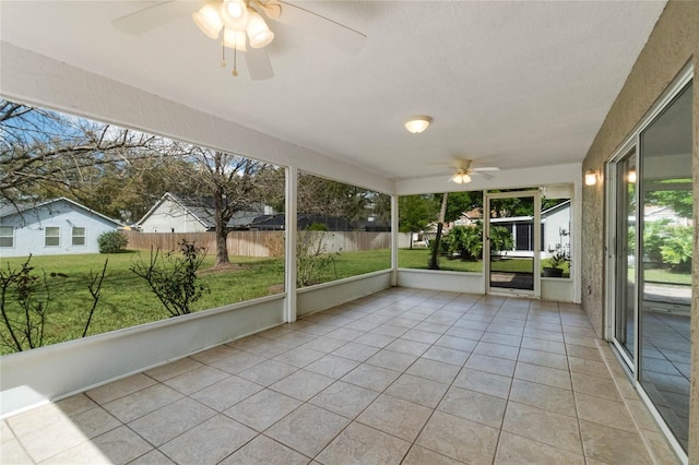 unfurnished sunroom featuring a ceiling fan