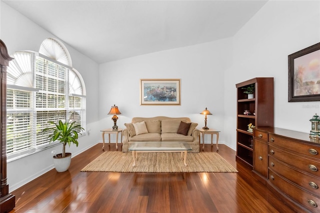 living area with vaulted ceiling, dark wood finished floors, and baseboards