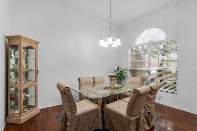 dining space featuring wood finished floors, baseboards, and an inviting chandelier