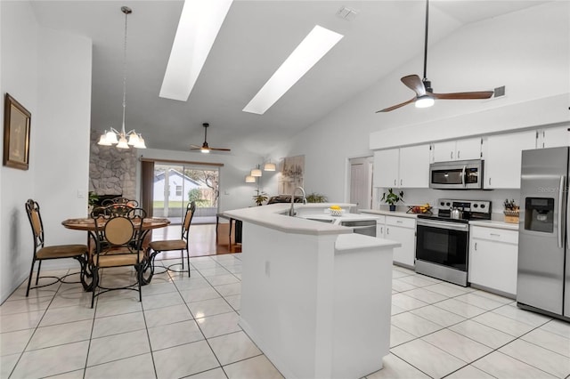 kitchen with light tile patterned floors, a skylight, a sink, light countertops, and appliances with stainless steel finishes