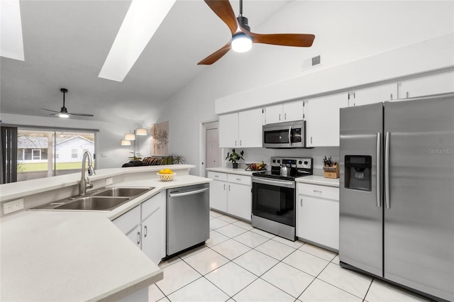 kitchen with light countertops, appliances with stainless steel finishes, a skylight, and a sink