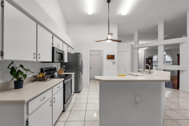 kitchen with light tile patterned floors, a sink, electric stove, light countertops, and stainless steel microwave