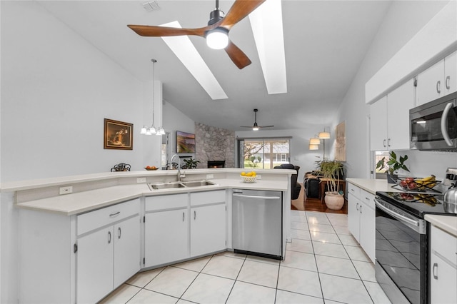 kitchen featuring light tile patterned floors, stainless steel appliances, light countertops, open floor plan, and a sink