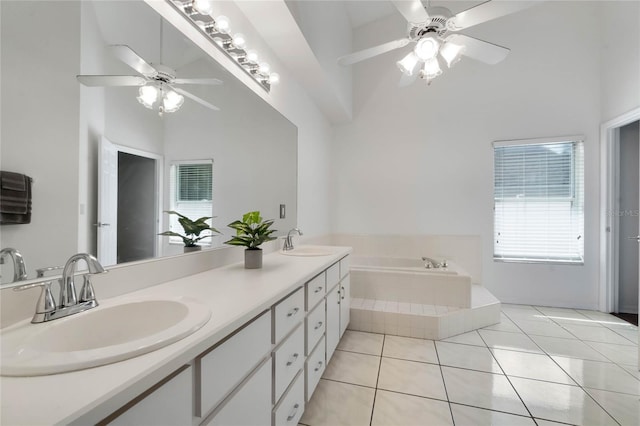 full bathroom featuring a towering ceiling, a garden tub, a sink, and tile patterned floors