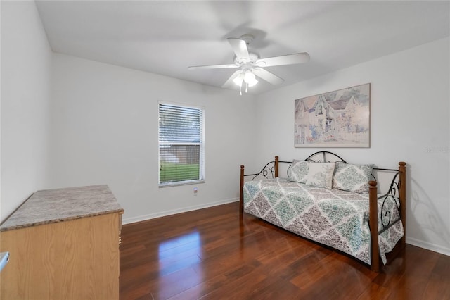 bedroom featuring wood finished floors, a ceiling fan, and baseboards