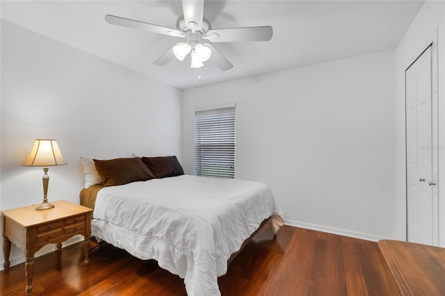 bedroom featuring ceiling fan, baseboards, and wood finished floors