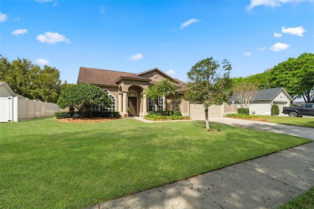 view of front of house featuring an attached garage, fence, driveway, stucco siding, and a front lawn