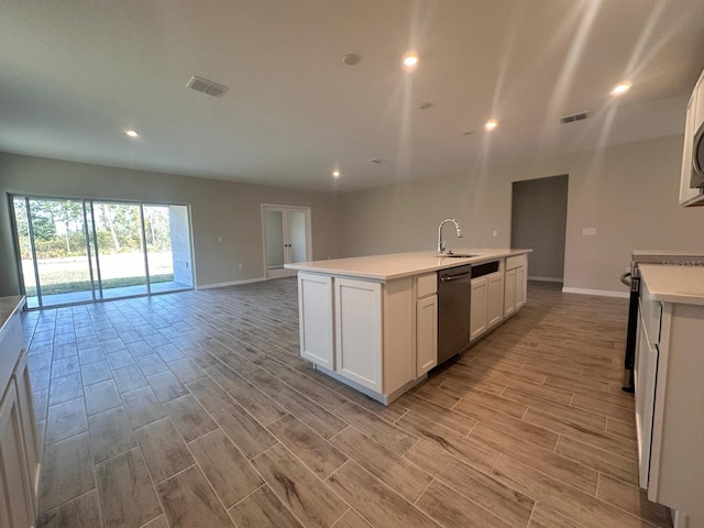 kitchen featuring white cabinetry, stainless steel appliances, sink, and a kitchen island with sink