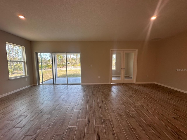 spare room with french doors, a textured ceiling, and hardwood / wood-style flooring