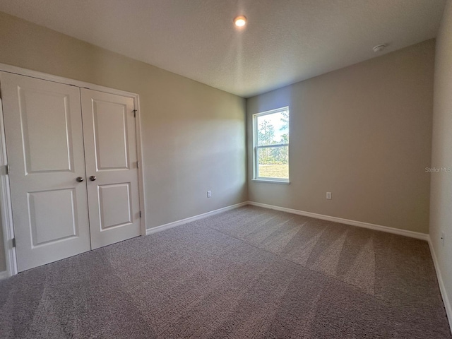 unfurnished bedroom with a closet, carpet, and a textured ceiling