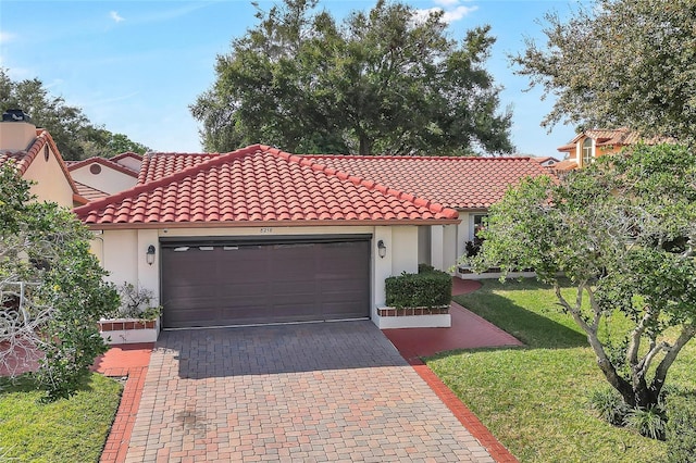 mediterranean / spanish-style home featuring a garage and a front lawn