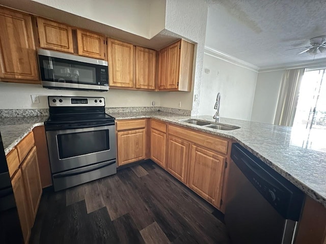 kitchen featuring sink, crown molding, a textured ceiling, dark hardwood / wood-style flooring, and stainless steel appliances