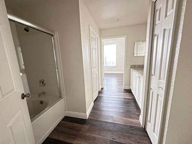 bathroom featuring hardwood / wood-style flooring, vanity, bathing tub / shower combination, and a textured ceiling