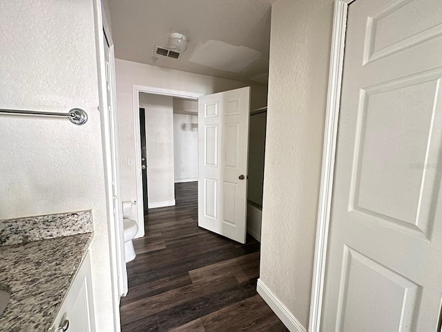 hallway with dark hardwood / wood-style flooring