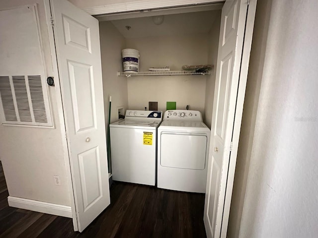 clothes washing area featuring dark wood-type flooring and washer and clothes dryer