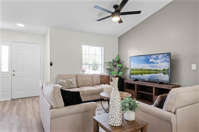 living room featuring vaulted ceiling, ceiling fan, and light wood-type flooring