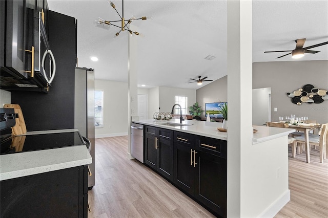 kitchen featuring sink, vaulted ceiling, light wood-type flooring, plenty of natural light, and stainless steel appliances