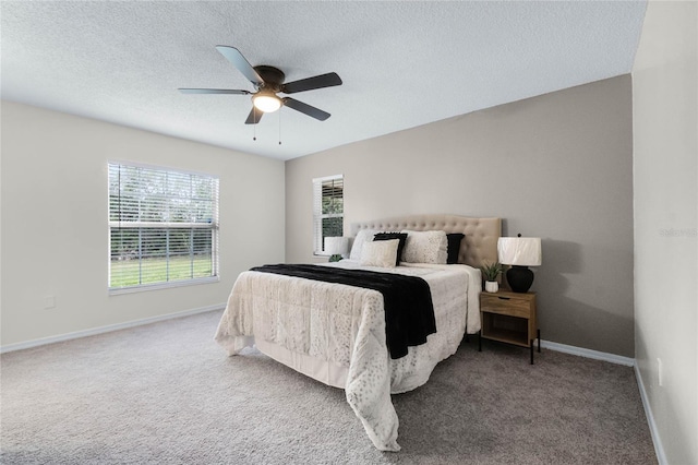 carpeted bedroom with ceiling fan and a textured ceiling