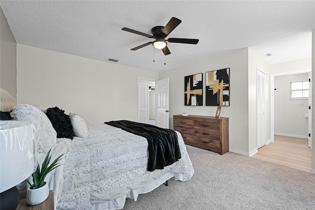 carpeted bedroom featuring ceiling fan and a textured ceiling