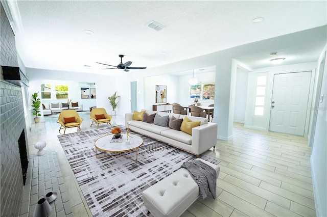 living room with plenty of natural light, a fireplace, visible vents, and baseboards